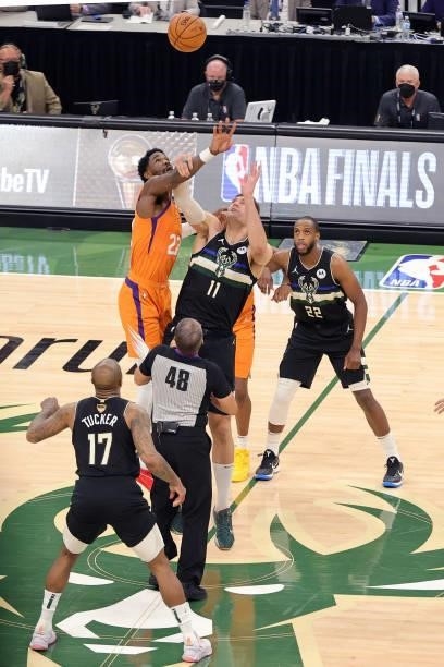 Brook Lopez of the Milwaukee Bucks tips off against Deandre Ayton of the Phoenix Suns during the first half in Game Six of the NBA Finals at Fiserv...