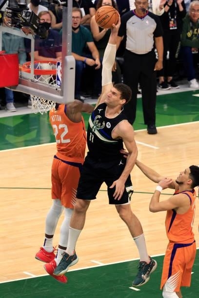 Brook Lopez of the Milwaukee Bucks dunks against Deandre Ayton of the Phoenix Suns during the second half in Game Six of the NBA Finals at Fiserv...