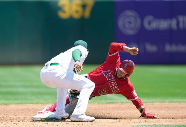 David Fletcher of the Los Angeles Angels steals second base sliding past the tag of Elvis Andrus of the Oakland Athletics in the top of the third...