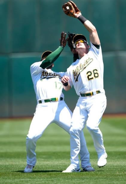 Matt Chapman of the Oakland Athletics avoids colliding with Elvis Andrus while catching a pop-up off the bat of Jared Walsh of the Los Angeles Angels...