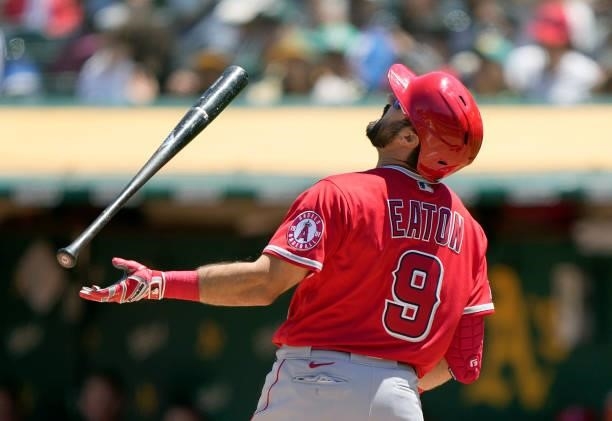 Adam Eaton of the Los Angeles Angels tosses his bat in the air reacting after he was called out on strike against the Oakland Athletics in the top of...
