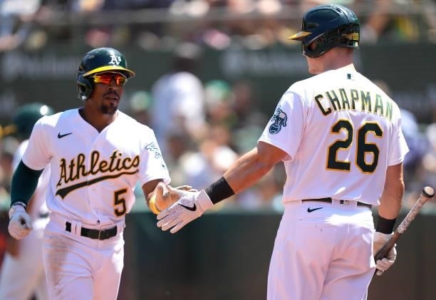 Tony Kemp of the Oakland Athletics is congratulated by Matt Chapman after Kemp scored against the Los Angeles Angels in the bottom of the six inning...