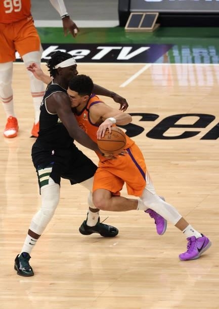 Devin Booker of the Phoenix Suns runs into Jrue Holiday of the Milwaukee Bucks during the second half in Game Six of the NBA Finals at Fiserv Forum...