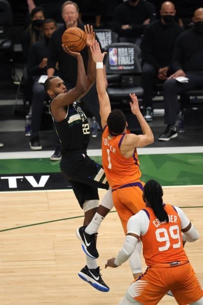 Khris Middleton of the Milwaukee Bucks shoots against Devin Booker of the Phoenix Suns during the second half in Game Six of the NBA Finals at Fiserv...