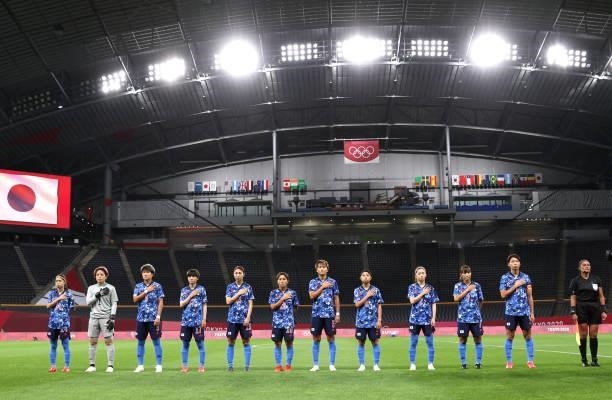Players of Team Japan stand for the national anthem prior to the Women's First Round Group E match between Japan and Canada during the Tokyo 2020...