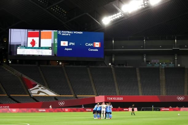 Players of Team Japan form a huddle as empty stands can be seen prior to the Women's First Round Group E match between Japan and Canada during the...