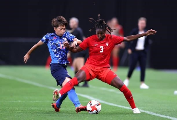 Mina Tanaka of Team Japan battles for possession with Kadeisha Buchanan of Team Canada during the Women's First Round Group E match between Japan and...
