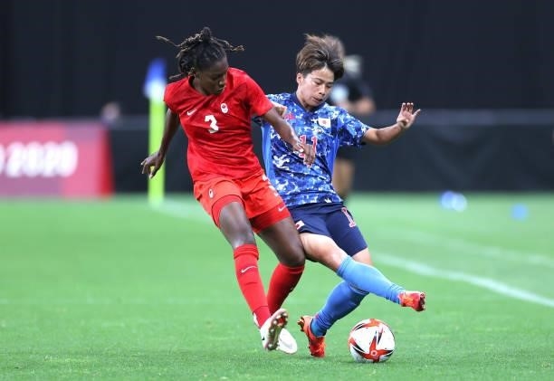 Mina Tanaka of Team Japan battles for possession with Kadeisha Buchanan of Team Canada during the Women's First Round Group E match between Japan and...