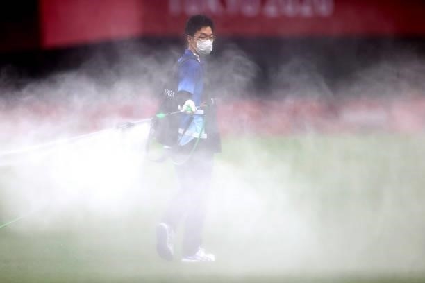 Member of ground staff waters the pitch prior to the Women's First Round Group E match between Japan and Canada during the Tokyo 2020 Olympic Games...