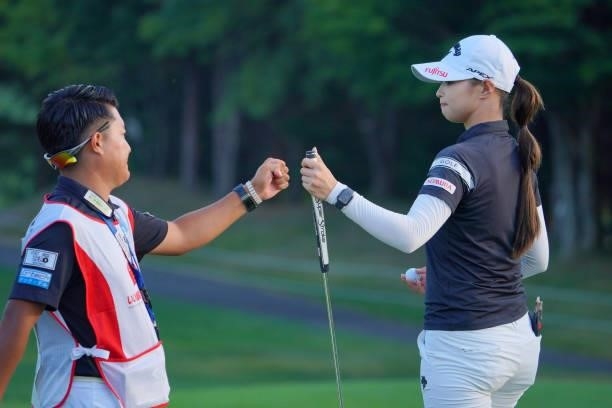 Asuka Kashiwabara of Japan fist bumps with her caddie after holing out with the birdie on the 18th green during the first round of Daito Kentaku...