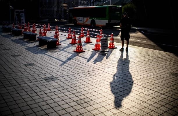 Journalist stands near a bus stop for media transport ahead of the Tokyo 2020 Olympic Games on July 22, 2021 in Tokyo, Japan.