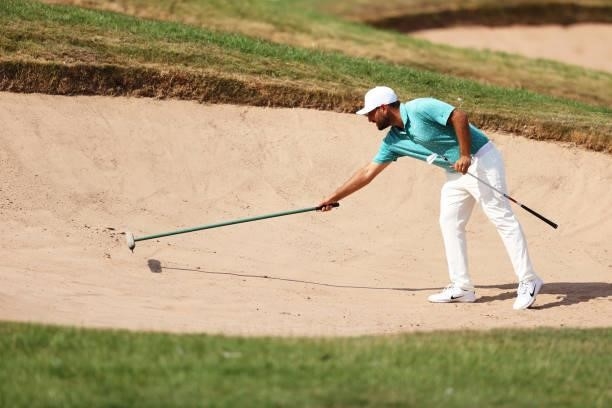 Alexander Levy of France rakes the bunker on hole 6 during Day One of the Cazoo Open supported by Gareth Bale at Celtic Manor Resort on July 22, 2021...