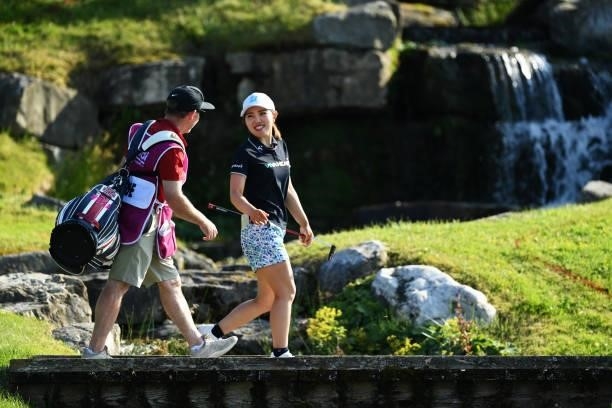Ayaka Furue of Japan walks over the bridge with her caddie on hole 18 during day one of the The Amundi Evian Championship at Evian Resort Golf Club...