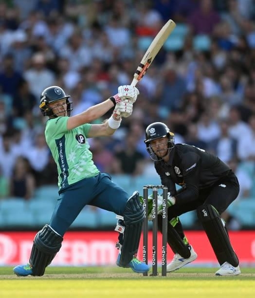 Sam Billings of Oval Invincibles hits out watched by Jos Buttler of Manchester Originals during the Hundred match between Oval Invincibles and...