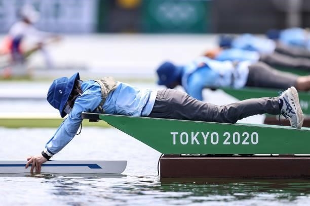 Volunteers hold the boats during the Women’s Single Sculls on on Day 0 of the Tokyo 2020 Olympic Games at Sea Forest Waterway on July 23, 2021 in...