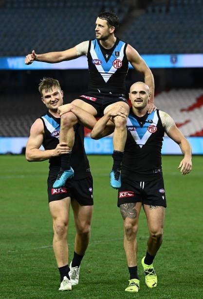 Travis Boak of the Power is chaired off by Ollie Wines and Sam Powell-Pepper of the Power in his 300th game during the round 19 AFL match between...