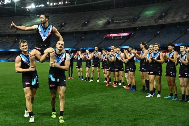 Travis Boak of the Power is chaired off by Ollie Wines and Sam Powell-Pepper of the Power in his 300th game during the round 19 AFL match between...