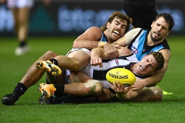 Taylor Adams of the Magpies is tackled by Scott Lycett and Travis Boak of the Power during the round 19 AFL match between Port Adelaide Power and...