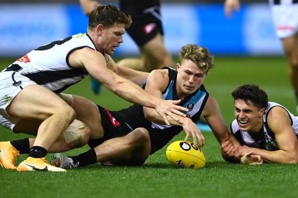 Xavier Duursma of the Power is tackled by Taylor Adams and Trent Bianco of the Magpies during the round 19 AFL match between Port Adelaide Power and...
