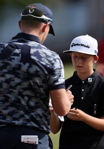 Matt Wallace of England signs a glove for a spectator during Day Two of the Cazoo Open supported by Gareth Bale at Celtic Manor Resort on July 23,...