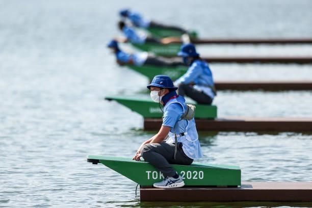 General view of volunteers who hold the boats during the Men's Single Sculls Repechage on day one of the Tokyo 2020 Olympic Games at Sea Forest...