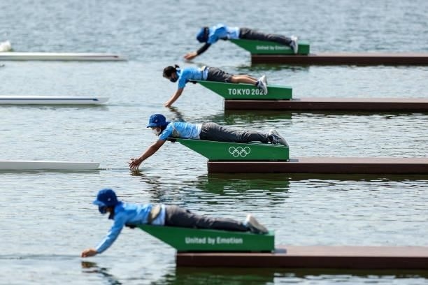 Volunteers let go of the boats during the Men's Single Sculls Repechage on day one of the Tokyo 2020 Olympic Games at Sea Forest Waterway on July 24,...