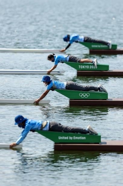 Volunteers hold the boats during the Men's Single Sculls Repechage on day one of the Tokyo 2020 Olympic Games at Sea Forest Waterway on July 24, 2021...