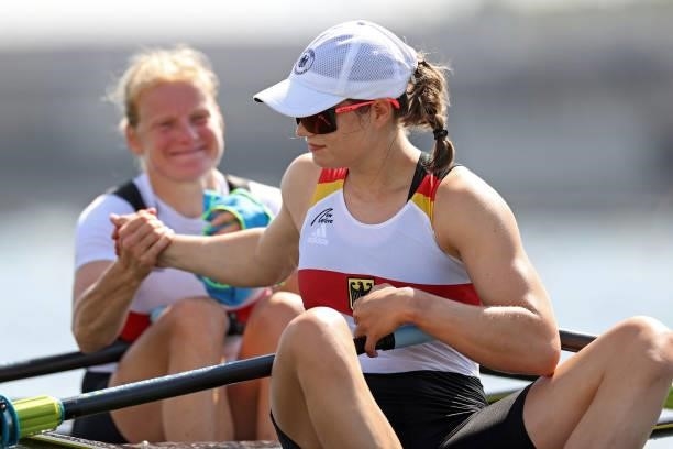 Leonie Menzel clasps hands with Annekatrin Thiele of Team Germany prior to the Women's Double Sculls Repechage 1 on day one of the Tokyo 2020 Olympic...