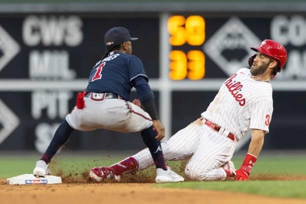 Bryce Harper of the Philadelphia Phillies slides in safely for a double past the tag of Ozzie Albies of the Atlanta Braves in the bottom of the third...