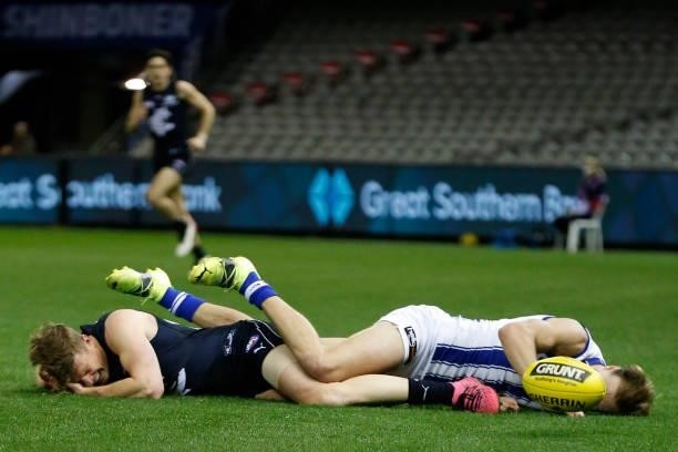 Benjamin McKay of the Kangaroos twists his ankle in a collision with Jack Newnes of the Blues during the round 19 AFL match between Carlton Blues and...