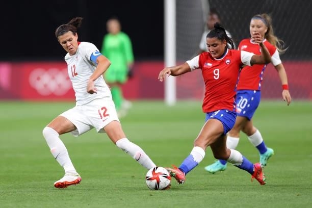 Christine Sinclair of Team Canada battles for possession with Jose Urrutia Maria of Team Chile during the Women's First Round Group E match between...
