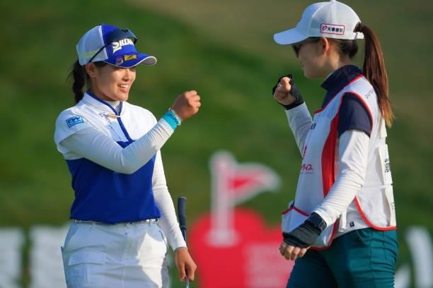 Sae Ogura of Japan fist bumps with her caddie after holing out with the birdie on the 18th green during the third round of Daito Kentaku eHeyanet...
