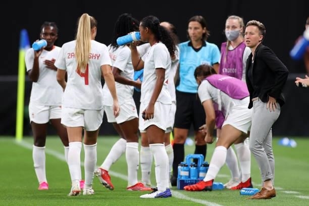 Bev Priestman, Head Coach of Team Canada looks on as Team Canada players take a drinks break during the Women's First Round Group E match between...