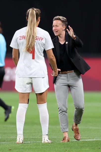 Bev Priestman, Head Coach of Team Canada celebrates with Shelina Zadorsky of Team Canada after victory in the Women's First Round Group E match...