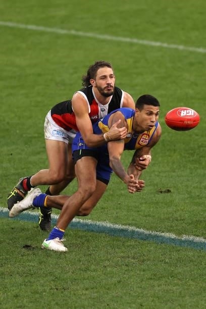 Tim Kelly of the Eagles handballs against Ben Long of the Saints during the round 19 AFL match between West Coast Eagles and St Kilda Saints at Optus...