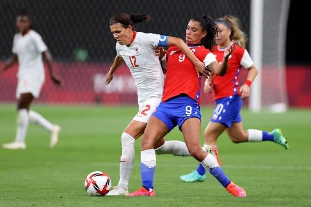 Christine Sinclair of Team Canada battles for possession with Jose Urrutia Maria of Team Chile during the Women's First Round Group E match between...