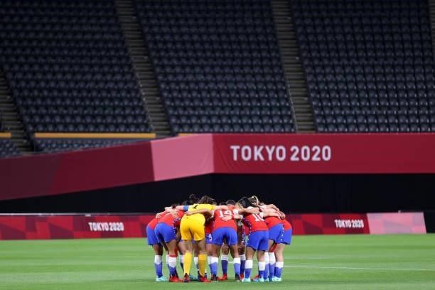 Players of Team Chile form a huddle as empty seats are seen prior to the Women's First Round Group E match between Chile and Canada on day one of the...