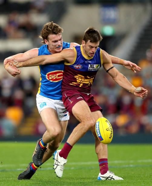 Jarryd Lyons of the Lions kicks the ball under pressure from Noah Anderson of the Suns during the round 20 AFL match between Brisbane Lions and Gold...