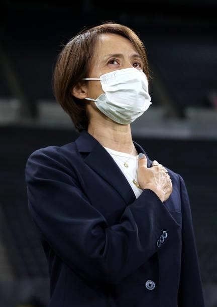 Asako Takakura, Head Coach of Team Japan wears a face mask during the national anthem prior to the Women's First Round Group E match between Japan...