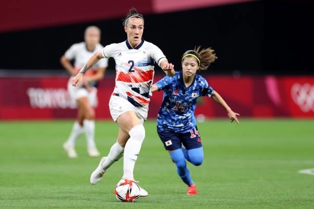 Lucy Bronze of Team Great Britain runs with the ball whilst under pressure from Yui Hasegawa of Team Japan during the Women's First Round Group E...