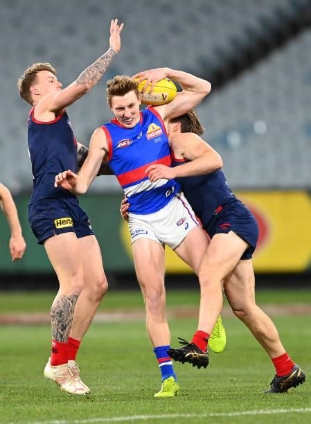 Bailey Dale of the Bulldogs is tackled by James Harmes and Jack Viney of the Demons during the round 20 AFL match between Melbourne Demons and...