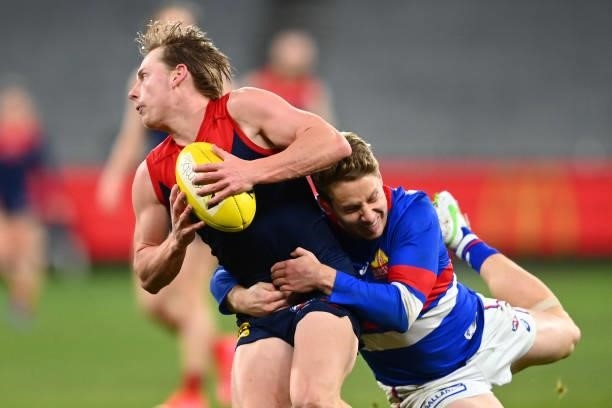 Charlie Spargo of the Demons is tackled by Lachie Hunter of the Bulldogs during the round 20 AFL match between Melbourne Demons and Western Bulldogs...