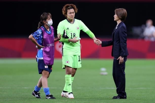 Asako Takakura, Head Coach of Team Japan shakes hands with Ayaka Yamashita of Team Japan following defeat in the Women's First Round Group E match...