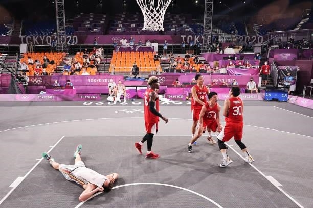 Keisei Tominaga of Team Japan celebrates hitting the winning basket as Nick Celis of Team Belgium lies down during the Men's Pool Round match between...