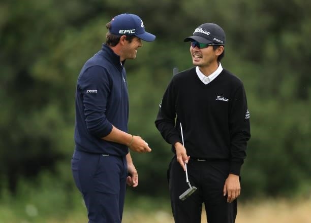 Nacho Elvira of Spain shows Masahiro Kawamura of Japan his ball which needed changing after thinning it out of the 18th greenside bunker during the...