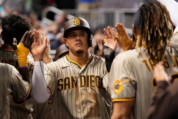 Manny Machado of the San Diego Padres celebrates with teammates in the dugout during the game against the Miami Marlins at loanDepot park on July 23,...