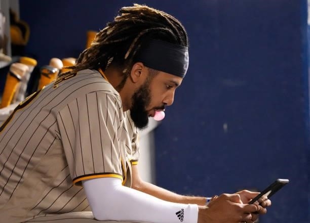 Fernando Tatis Jr. #23 of the San Diego Padres views a tablet in the dugout during the game against the Miami Marlins at loanDepot park on July 23,...