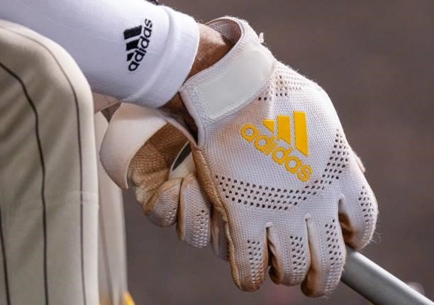 Detailed view of the Adidas batting glove of Fernando Tatis Jr. #23 of the San Diego Padres while holding his Victus bat int the dugout during the...