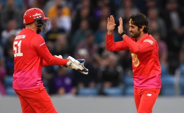 Welsh Fire bowler Qais Ahmad celebrates after taking the wicket of John Simpson with Jonny Bairstow during The Hundred match between Northern...