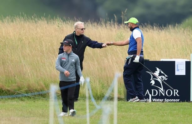 Keith Pelley, CEO of the European Tour fist pumps Tomasso Perrino of Italy, on the first tee during the third round of the Cazoo Open supported by...